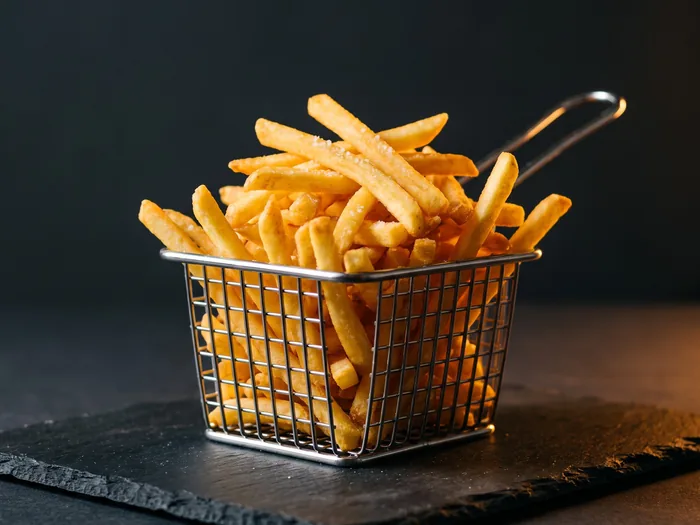 Porção de batata frita sequinha e salpicada com sal